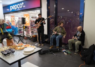 Skupina lidí hrajících hudbu v nákupním středisku.
